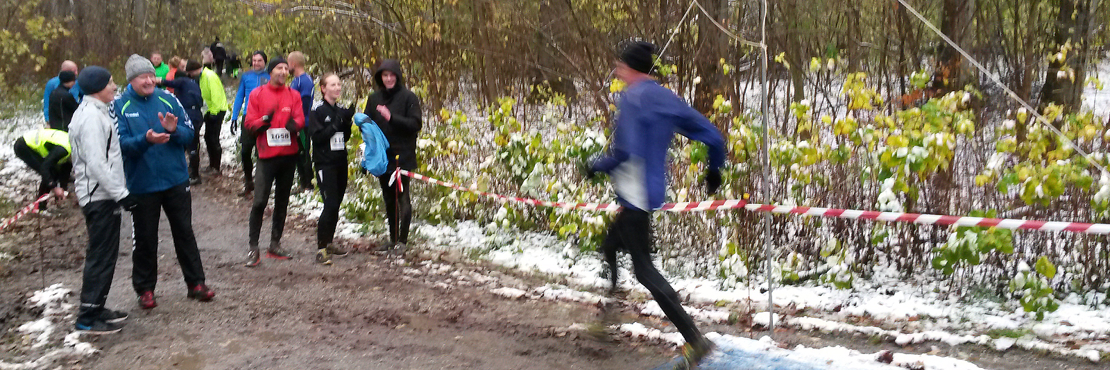 Løber i fuld fart passerer målstregen i mudder og sne